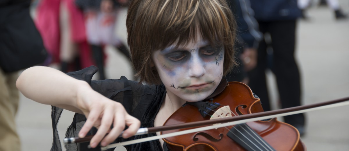 A zombie child playing the violin.